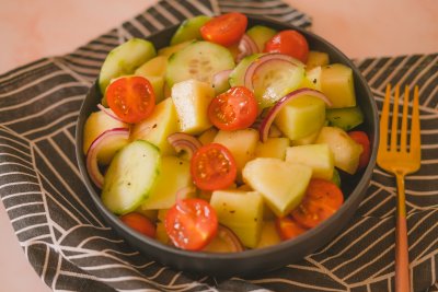 Delicious Cantaloupe Salad with juicy melon, tomatoes, cucumbers, onion and dressing