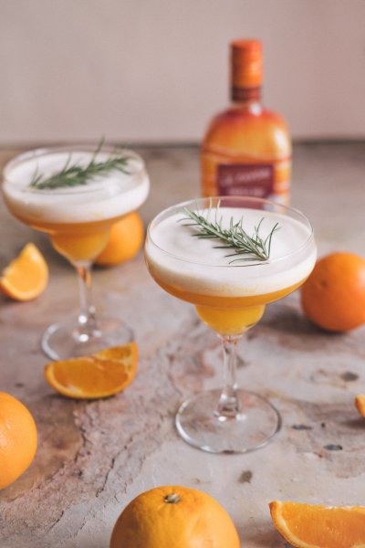 Fresh triple sec cocktail served in a beautiful cocktail glass and decorated with a fresh rosemary sprig