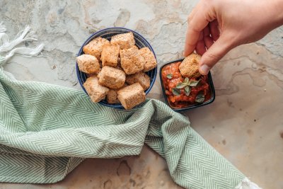 Healthy baked tofu nuggets served with tomato dip on the side