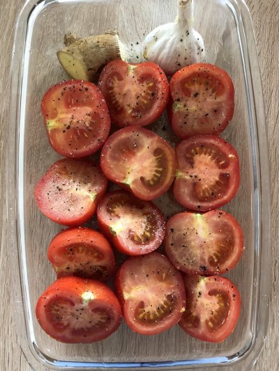 place tomatoes ginger and garlic, olive oil on a baking tray