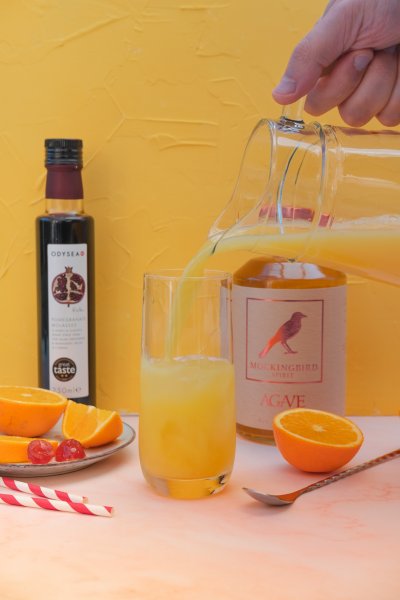 Step 3 in making tequila sunrise mocktail - add orange juice