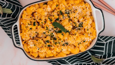 Delicious pumpkin pasta served in a cute tray with vegan parmesan and herbs
