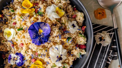 Summer cous cous with fresh vegetables and edible flowers