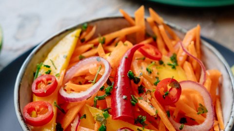 Healthy carrot mango salad in a beautiful bowl with all fresh ingredients